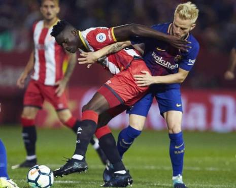 GRA665. Girona, 23/09/2017.- El delantero keniata del Girona, Michael Olunga (i), protege el balón ante el acoso del centrocampista croata del FC Barcelona, Ivan Rakitic, durante el encuentro correspondiente a la sexta jornada de primera división que disputan esta noche en el estadio Montilivi de Girona. EFE / Alejandro Garcia.