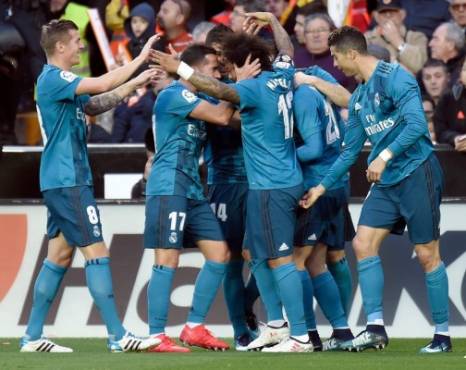 Real Madrid's Brazilian defender Marcelo (C) celebrates a goal with teammates during the Spanish league football match between Valencia CF and Real Madrid CF at the Mestalla stadium in Valencia on January 27, 2018. / AFP PHOTO / JOSE JORDAN
