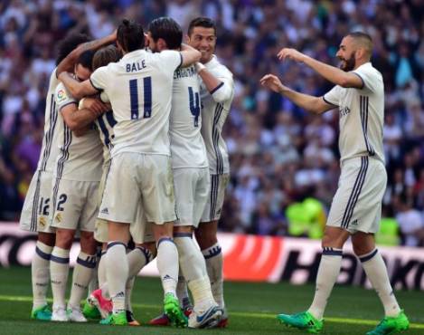 Real Madrid players celebrate their opening goal during the Spanish league football match Real Madrid CF vs Club Atletico de Madrid at the Santiago Bernabeu stadium in Madrid on April, 8, 2017. / AFP PHOTO / GERARD JULIEN
