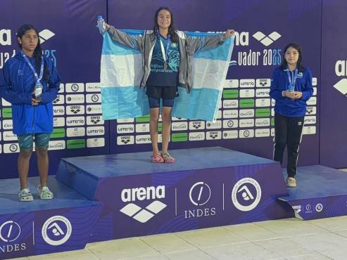 Elisa levantando con orgullo la bandera de Honduras al recibir su medalla de oro en El Salvador.
