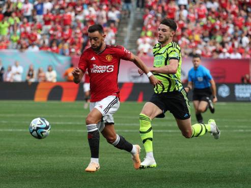 Bruno Fernandes conduce el balón ante la marca de Declan Rice, volante del Arsenal de Inglaterra.
