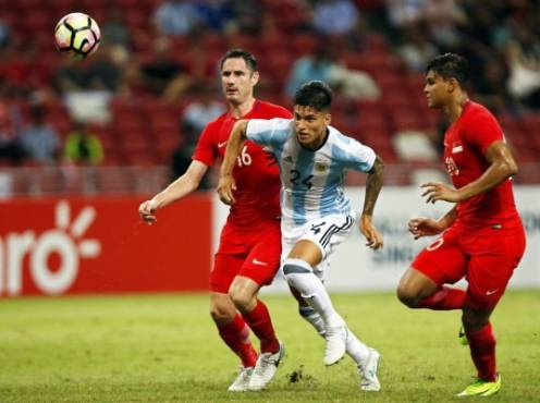 SIN01 SINGAPUR (SINGAPUR) 13/06/2017.- El futbolista argentino Joaquín Correa (c) se enfrenta a los singapurenses Daniel Bennett (izq) y Irfan Fandi (dcha) durante un partido amistoso disputado en el Estadio Nacional en Singapur, hoy, 13 de junio 2017. EFE/Wallace Woon
