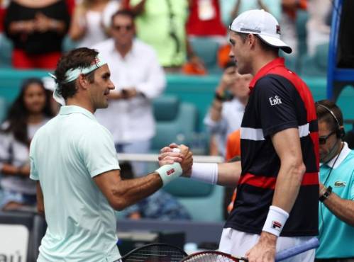 MIAMI GARDENS, FLORIDA - MARCH 31: Roger Federer of Switzerland meets John Isner at the net after defeating him in straight sets during the Men's Final match on day 14 of the Miami Open presented by Itau at Hard Rock Stadium on March 31, 2019 in Miami Gardens, Florida. Al Bello/Getty Images/AFP