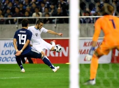 Uruguay's defender Marcelo Saracchi (C) kicks the ball beside Japan's defender defender Hiroki Sakai (L) during the international football friendly match between Japan and Uruguay in Saitama on October 16, 2018. (Photo by TOSHIFUMI KITAMURA / AFP)