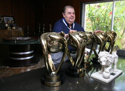 Rafael Ferrari exhibiendo algunas de las tantas copas que logró como presidente del Olimpia.