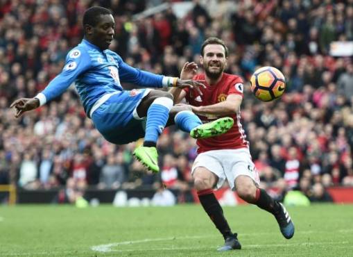Bournemouth's Ivorian midfielder Max Gradel (L) clears the ball under pressure from Manchester United's Spanish midfielder Juan Mata during the English Premier League football match between Manchester United and Bournemouth at Old Trafford in Manchester, north west England, on March 4, 2017.The game finished 1-1. / AFP PHOTO / Oli SCARFF / RESTRICTED TO EDITORIAL USE. No use with unauthorized audio, video, data, fixture lists, club/league logos or 'live' services. Online in-match use limited to 75 images, no video emulation. No use in betting, games or single club/league/player publications. /