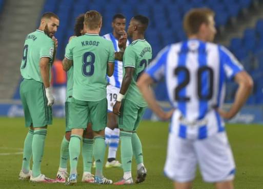 Real Madrid's French forward Karim Benzema (L) celebrates with teammates after scoring during the Spanish League football match between Real Sociedad and Real Madrid at the Reale Arena-Anoeta Stadium in San Sebastian on June 21, 2020. (Photo by ANDER GILLENEA / AFP)