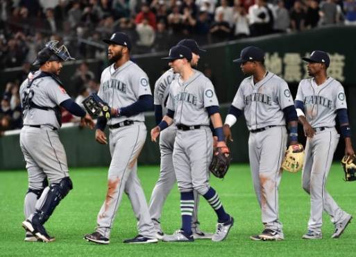 Seattle Mariners catcher Omar Narvaez (L) and his teammates celebrate celebrate their win over Oakland Athletics after the bottom of the 12th inning at the Major League Baseball Japan Opening Series in Tokyo on March 21, 2019. - Japanese hit king Ichiro Suzuki announced his retirement on March 21, calling time on a record-breaking career that saw him shatter a host of Major League Baseball milestones. Baseball MLB Mariners Suzuki (Photo by Kazuhiro NOGI / AFP)