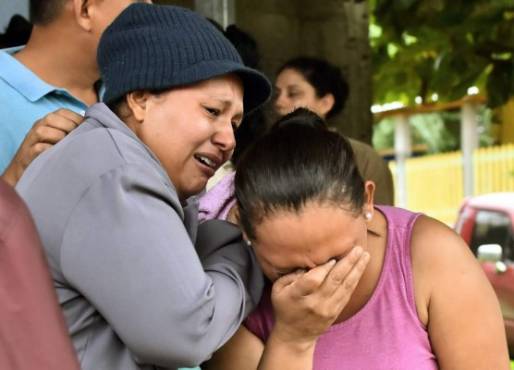 Relatives of inmates react after getting information about their loved ones in front of the penitentiary of Tela, Atlantida department, Honduras, on December 21, 2019, following clashes ocurred at the jail. - At least 18 inmates died and 16 were injured in overnight clashes between prisoners in Honduras after fighting erupted at a jail in the northern port town of Tela, prison officials said Saturday. (Photo by STR / AFP)