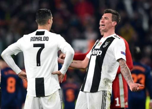 Juventus' Croatian forward Mario Mandzukic (R) and Juventus' Portuguese forward Cristiano Ronaldo (L) react at the end of the UEFA Champions League group H football match Juventus vs Valence on November 27, 2018 at the Juventus stadium in Turin. (Photo by Miguel MEDINA / AFP)