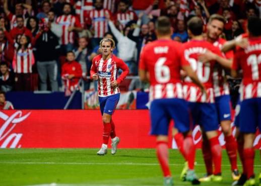 Atletico Madrid's forward from France Antoine Griezmann (L) looks at his teammates celebrate after scoring after scoring during the Spanish league football match Club Atletico de Madrid vs Malaga CF at the Wanda Metropolitano stadium in Madrid on September 16, 2017. / AFP PHOTO / OSCAR DEL POZO