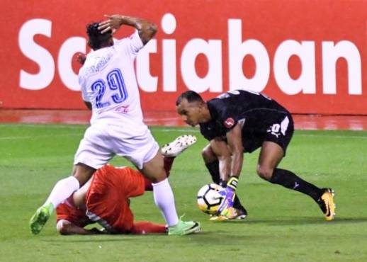 Costa Rica's Santos de Guapiles player Reimond Salas (BACK) vies for the ball with Honduras Olimpia player German Mejia (L) and goalkeeper Edrick Menjivar (R) during their Concacaf League football final at the National Stadium in San Jose, Costa Rica, on October 26, 2017. / AFP PHOTO / Ezequiel BECERRA