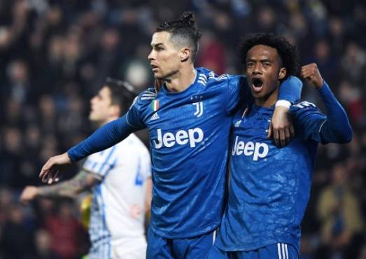 Juventus' Portuguese forward Cristiano Ronaldo (L) celebrates with Juventus' Colombian midfielder Juan Cuadrado after opening the scoring during the Italian Serie A football match SPAL vs Juventus on February 22, 2020 at the Paolo-Mazza stadium in Ferrara. (Photo by Isabella BONOTTO / AFP)
