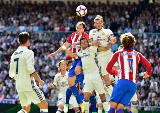 Atletico Madrid's Uruguayan defender Diego Godin (top L) vies with Real Madrid's Welsh forward Gareth Bale (top R) and Real Madrid's Portuguese defender Pepe during the Spanish league football match Real Madrid CF vs Club Atletico de Madrid at the Santiago Bernabeu stadium in Madrid on April, 8, 2017. / AFP PHOTO / GERARD JULIEN