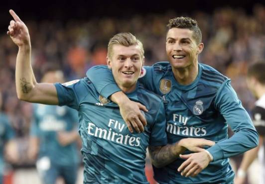Real Madrid's German midfielder Toni Kroos (L) celebrates a goal with Real Madrid's Portuguese forward Cristiano Ronaldo during the Spanish league football match between Valencia CF and Real Madrid CF at the Mestalla stadium in Valencia on January 27, 2018. / AFP PHOTO / JOSE JORDAN