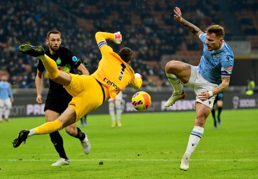 Lazio's Italy's forward Ciro Immobile (R) fights for the ball with Inter Milan's Slovenian goalkeeper Samir Handanovic (L) on his way to scoring a goal during the Serie A football match betweenInter Milan and Lazio at the Meazza stadium in Milan on January 9, 2022. (Photo by MIGUEL MEDINA / AFP)