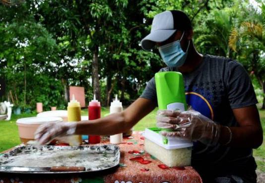 Lázaro Yánez atendiendo su negocio de venta de “perros calientes”