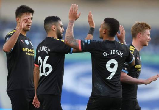 Manchester City's Spanish midfielder Rodri (L), Manchester City's Algerian midfielder Riyad Mahrez (2L) and Manchester City's Belgian midfielder Kevin De Bruyne (R) celebrate with goal scorer Manchester City's Brazilian striker Gabriel Jesus during the English Premier League football match between Brighton and Hove Albion and Manchester City at the American Express Community Stadium in Brighton, southern England on July 11, 2020. (Photo by Catherine Ivill / POOL / AFP) / RESTRICTED TO EDITORIAL USE. No use with unauthorized audio, video, data, fixture lists, club/league logos or 'live' services. Online in-match use limited to 120 images. An additional 40 images may be used in extra time. No video emulation. Social media in-match use limited to 120 images. An additional 40 images may be used in extra time. No use in betting publications, games or single club/league/player publications. /