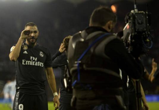 Real Madrid's French forward Karim Benzema gestures to a TV camera as he celebrates scoring the opening goal during the Spanish league football match between RC Celta de Vigo and Real Madrid CF at the Balaidos stadium in Vigo on November 11, 2018. (Photo by MIGUEL RIOPA / AFP)