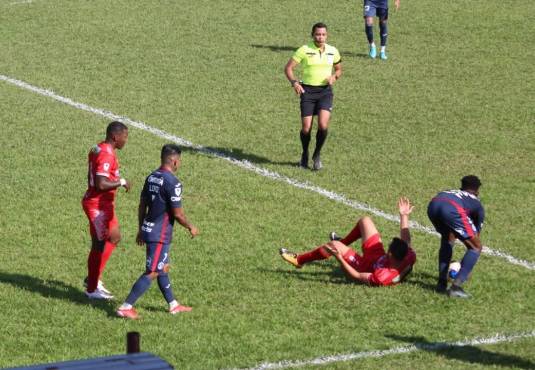 Jonathan Núñez intenta jugar rápido ante la mirada del árbitro Selvin Brown. Foto: Dagoberto Luján.