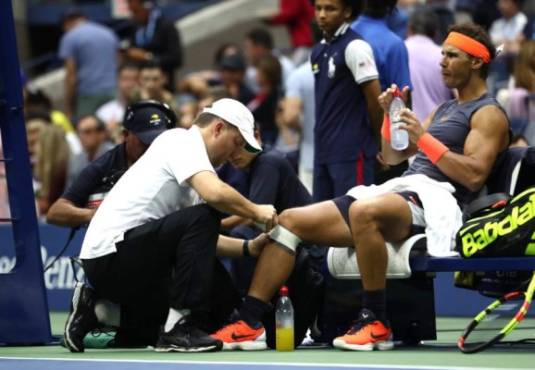 NEW YORK, NY - SEPTEMBER 07: Rafael Nadal of Spain is looked at by the trainer during his men's singles semi-final match against Juan Martin del Potro of Argentina on Day Twelve of the 2018 US Open at the USTA Billie Jean King National Tennis Center on September 7, 2018 in the Flushing neighborhood of the Queens borough of New York City. Al Bello/Getty Images/AFP
