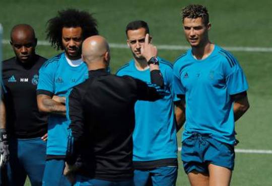 GRAF2883. MADRID, 22/05/2018.- El entrenador del Real Madrid, Zinedine Zidane (2d, de espaldas), da instrucciones a sus jugadores, Cristiano Ronaldo (d), Lucas Vázquez (2d), y Marcelo Vieira (2i), durante el Día de Puertas Abiertas para los medios celebrado hoy en las instalaciones de Valdebebas, previo a la final de la Liga de Campeones que el conjunto blanco disputa ante el Liverpool el día 26 de mayo en el Estadio Olímpico de Kiev. EFE/Juan Carlos Hidalgo
