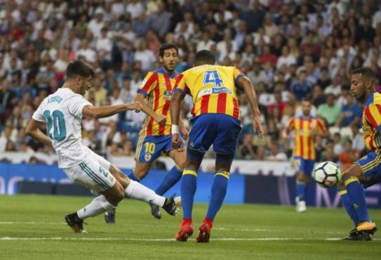 Real Madrid's midfielder Marcos Asensio (L) scores the opener during the Spanish league football match Real Madrid CF vs Valencia CF at the Santiago Bernabeu stadium in Madrid on August 27, 2017. / AFP PHOTO / CURTO DE LA TORRE