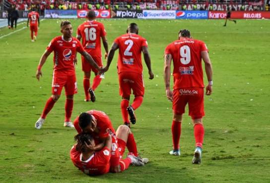 America de Cali's midfielder Carlos Sierra (bottom) celebrates with a teammate his goal against Atletico Junior during the Colombian First Division Football Championship final match at the Olimpico Pascual Guerrero stadium in Cali, Colombia, on December 7, 2019. (Photo by LUIS ROBAYO / AFP)