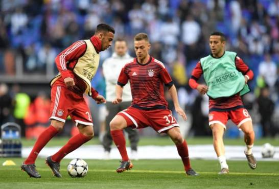 (L-R) Bayern Munich's French midfielder Corentin Tolisso, Bayern Munich's German midfielder Joshua Kimmich and Bayern Munich's Spanish midfielder Thiago Alcantara warm up prior to the UEFA Champions League semi-final second-leg football match Real Madrid CF vs FC Bayern Munich in Madrid, Spain, on May 1, 2018. / AFP PHOTO / GABRIEL BOUYS