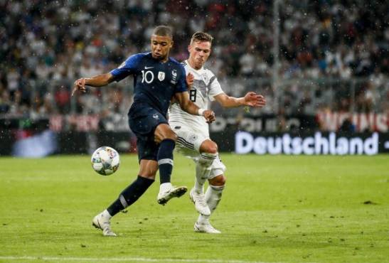 AL01. MUNICH (ALEMANIA), 06/09/2018.- Joshua Kimmich (d) de la selección de Alemania disputa un balón con Kylian Mbappe (i) de la selección de Francia hoy, jueves 6 de agosto de 2018, durante el partido de fútbol de la Liga de las Naciones UEFA, entre las selecciones nacionales de fútbol de Alemania y Francia, en Munich (Alemania). EFE/RONALD WITTEK ** Las regulaciones de DFB prohíben el uso de fotografías como secuencias de imágenes y / o cuasivídeo. **