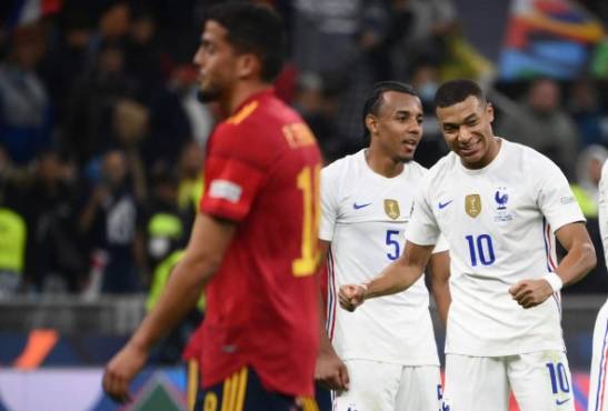 France's forward Kylian Mbappe (R) and France's defender Jules Kounde (C) celebrate their victory at the end of the Nations League final football match between Spain and France at San Siro stadium in Milan, on October 10, 2021. (Photo by FRANCK FIFE / AFP)
