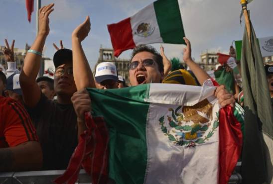 Fans of Mexico cheer for their team during the broadcasting of the 2018 World Cup Group F football match between Mexico and Sweden, at a public event at the Zocalo Square in Mexico City, on June 27, 2018. / AFP PHOTO / JOHAN ORDONEZ