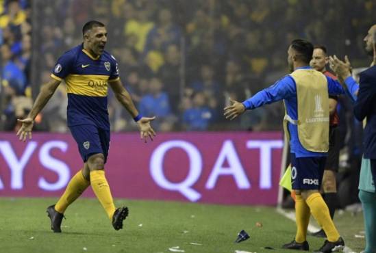 Argentina's Boca Juniors forward Ramon Abila (L) celebrates with teammate forward Carlos Tevez (2-R) after scoring a goal against Brazil's Athletico Paranaense during a Copa Libertadores sixteen round second leg football match at the 'Bombonera' stadium in Buenos Aires, Argentina, on July 31, 2019. (Photo by JUAN MABROMATA / AFP)
