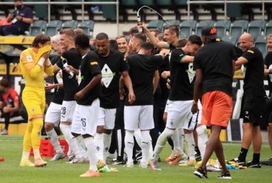 Borussia Moenchengladbach players celebrate at the end of the German first division Bundesliga football match Borussia Moenchengladbach v Hertha Berlin on June 27, 2020 in Moenchengladbach. (Photo by WOLFGANG RATTAY / POOL / AFP) / DFL REGULATIONS PROHIBIT ANY USE OF PHOTOGRAPHS AS IMAGE SEQUENCES AND/OR QUASI-VIDEO