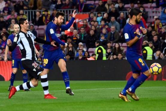 Barcelona's Argentinian forward Lionel Messi (3L) shoots to score a goal during the Spanish league football match FC Barcelona vs Levante UD at the Camp Nou stadium in Barcelona on January 7, 2018. / AFP PHOTO / Josep LAGO