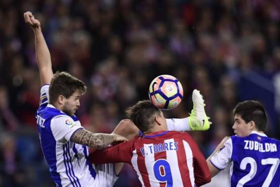 Atletico Madrid's forward Fernando Torres (C) vies with Real Sociedad's defender Inigo Martinez Berridi (L) and Real Sociedad's defender Igor Zubeldia during the Spanish league football match Club Atletico de Madrid vs Real Sociedad at the Vicente Calderon stadium in Madrid on April 4, 2017. / AFP PHOTO / JAVIER SORIANO