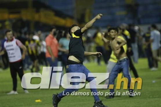 Aficionados captados en el momento mientras lanzaban objetos peligrosos en el enfrentamiento entre las barras.