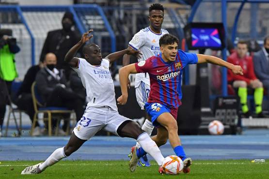 Real Madrid's French defender Ferland Mendy (L) marks Barcelona's Moroccan forward Abde Ezzalzouli during the Spanish Super Cup semi-final football match between Barcelona and Real Madrid at the King Fahad International stadium in the Saudi capital Riyadh on January 12, 2022. (Photo by AFP)