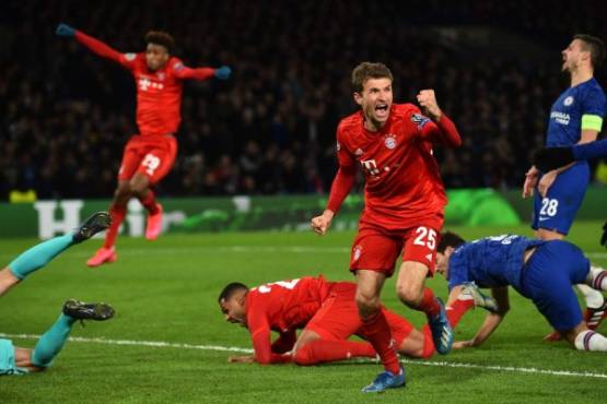 Bayern Munich's German striker Thomas Mueller (3rd R) celebrates after Bayern Munich's German striker Serge Gnabry (C) scores the opening goal of the UEFA Champion's League round of 16 first leg football match between Chelsea and Bayern Munich at Stamford Bridge in London on February 25, 2020. (Photo by Glyn KIRK / AFP)