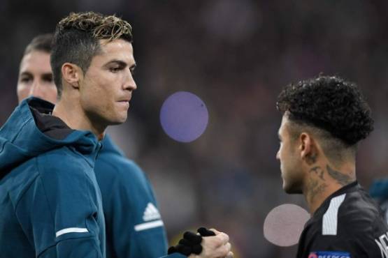 Real Madrid's Portuguese forward Cristiano Ronaldo (L) shakes hands with Paris Saint-Germain's Brazilian forward Neymar (R) before the UEFA Champions League round of sixteen first leg football match Real Madrid CF against Paris Saint-Germain (PSG) at the Santiago Bernabeu stadium in Madrid on February 14, 2018. / AFP PHOTO / GABRIEL BOUYS