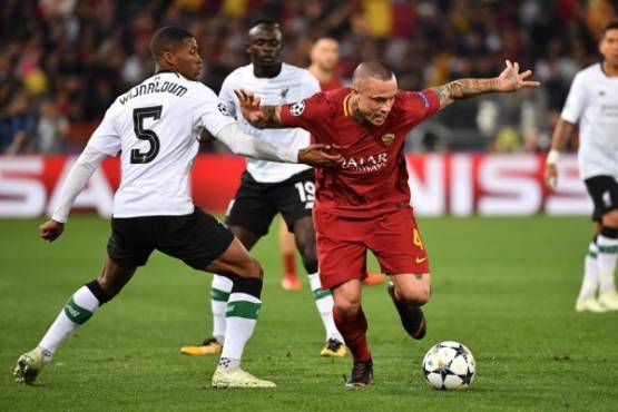 Liverpool's Dutch midfielder Georginio Wijnaldum (L) vies Liverpool's Dutch defender Virgil van Dijk during the UEFA Champions League semi-final second leg football match AS Roma vs Liverpool FC at the Stadio Olimpico in Rome on May 2, 2018. / AFP PHOTO / Alberto PIZZOLI