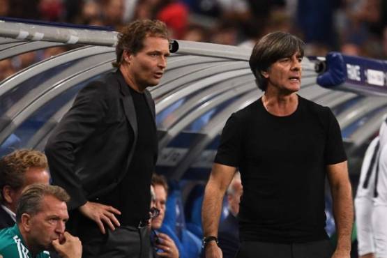 (FILES) In this file photo taken on October 17, 2018 Germany's head coach Joachim Loew (R) reacts past Germany's assistant coach Marcus Sorg during the UEFA Nations League football match between France and Germany at the Stade de France in Saint-Denis, near Paris. - Loew had to go into treatment after a sports accident and will be replaced by his assistant Marcus Sorg at the upcoming European Championship qualifying matches. (Photo by Anne-Christine POUJOULAT / AFP)