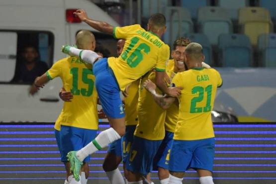 Brazil's players celebrate teammate Eder Militao's (hidden) goal against Ecuador during the Conmebol Copa America 2021 football tournament group phase match at the Olympic Stadium in Goiania, Brazil, on June 27, 2021. (Photo by NELSON ALMEIDA / AFP)