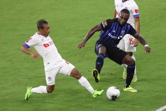 ORLANDO, FL - DECEMBER 15: Javier Portillo #25 (L) of CD Olimpia competes for the ball against Zachary Brault-Guillard #15 of Montreal Impact during the CONCACAF Champions League quarterfinal game at Exploria Stadium on December 15, 2020 in Orlando, Florida. Alex Menendez/Getty Images/AFP== FOR NEWSPAPERS, INTERNET, TELCOS & TELEVISION USE ONLY ==