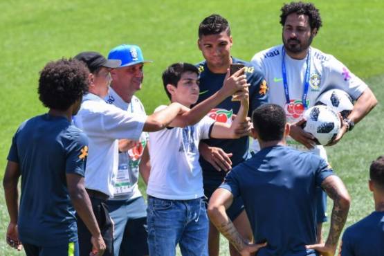 A fan takes a picture with Brazil's Casemiro (C) during a training session at Sochi Municipal Stadium in Sochi on June 12, 2018, ahead of the Russia 2018 World Cup football tournament. / AFP PHOTO / NELSON ALMEIDA
