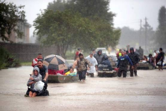 HOUSTON, TX - AUGUST 28: People are rescued from a flooded neighborhood after it was inundated with rain water, remnants of Hurricane Harvey, on August 28, 2017 in Houston, Texas. Harvey, which made landfall north of Corpus Christi late Friday evening, is expected to dump upwards to 40 inches of rain in areas of Texas over the next couple of days. Scott Olson/Getty Images/AFP