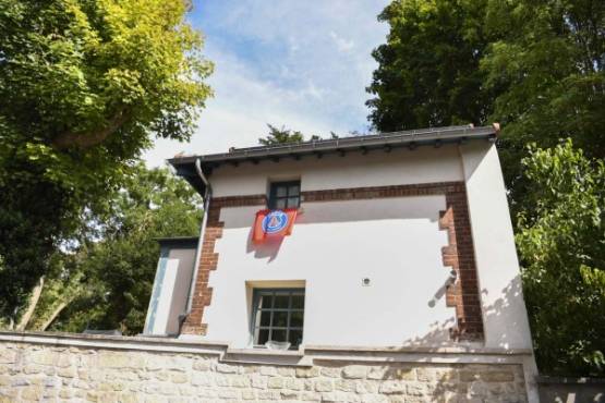 A French L1 Paris Saint-Germain fan flag is pictured at the window of a house neighbouring the one of Brazilian superster Neymar in Bougival, a western Paris suburb, on September 1, 2017. After weeks in a Paris palace hotel, French L1 Paris Saint-Germain's superstar Neymar settled in a 5-storey luxury house in Bougival, that includes 5,000 square -meters of land and an indoors pool. / AFP PHOTO / CHRISTOPHE SIMON