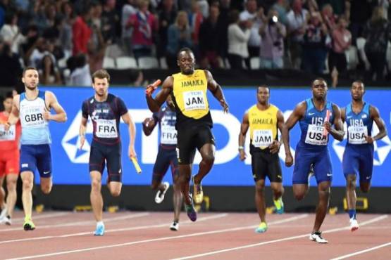 Jamaica's Usain Bolt (C) falls on Jamaica's anchor leg of the final of the men's 4x100m relay athletics event at the 2017 IAAF World Championships at the London Stadium in London on August 12, 2017. / AFP PHOTO / Jewel SAMAD