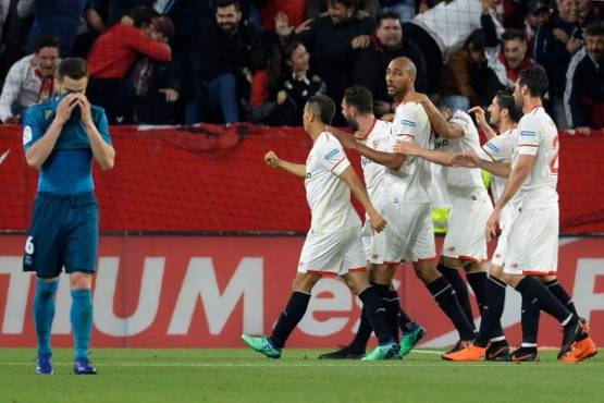 Real Madrid's Spanish defender Nacho Fernandez (L) reacts as Sevilla's players celebrate after scoring a goal during the Spanish league football match between Sevilla and Real Madrid at the Ramon Sanchez Pizjuan stadium in Sevilla on May 9, 2018. / AFP PHOTO / CRISTINA QUICLER