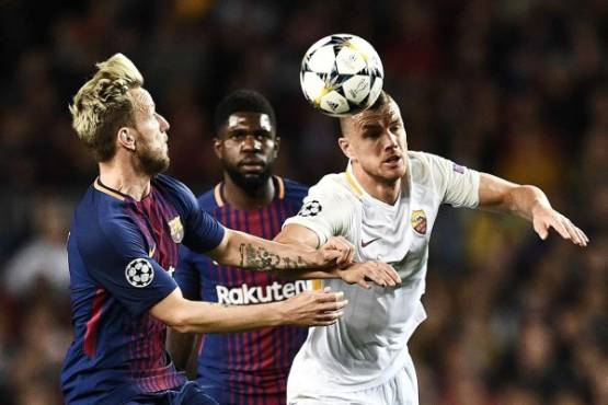 Roma's Bosnian striker Edin Dzeko (R) challenges Barcelona's Croatian midfielder Ivan Rakitic (L) and Barcelona's French defender Samuel Umtiti (C) during the UEFA Champions League quarter-final first leg football match between Barcelona and AS Roma at the Camp Nou Stadium in Barcelona on April 4, 2018. / AFP PHOTO / Filippo MONTEFORTE